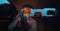 Businessman wearing face mask sitting on backseat of car and using smartphone