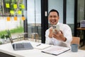 A businessman wearing a formal suit is at work. He sat in front of his laptop computer,