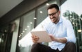 Businessman wearing glasses holding tablet and smiling Royalty Free Stock Photo