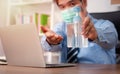 Businessman wearing a mask and use hand sanitizer on his desk for prevention or antibacterial hygiene and Coronavirus disease at