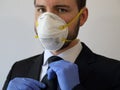 Businessman Wearing N95 Dust Mask Adjusting Necktie While Wearing Protective Rubber Gloves