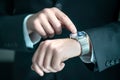 Businessman wearing smart watch with banking, finance or business report app. Man in suit using wearable gadget for work.