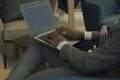 Businessman wearing suit holding laptop on his lap and looking into banking charts