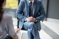 Businessman wearing suit and tie sitting and talking to journalist