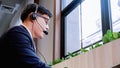 Businessman wearing telephone headset talking to caller in customer services department. Royalty Free Stock Photo