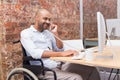 Businessman in wheelchair working at his desk on the phone Royalty Free Stock Photo