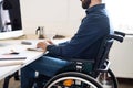 Businessman in wheelchair working in his office.