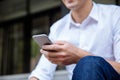 Businessman in white shirt sitting and using cell phone outdoors Royalty Free Stock Photo