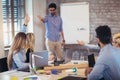 Businessman At Whiteboard Giving Presentation