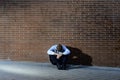 Businessman who lost job lost in depression sitting on city street corner Royalty Free Stock Photo