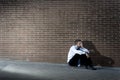 Businessman who lost job lost in depression sitting on city street corner Royalty Free Stock Photo