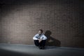 Businessman who lost job lost in depression sitting on city street corner Royalty Free Stock Photo