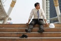 Businessman who are tired or stressed sitting alone on stairs