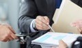 Businessman and woman discussing on stockmarket charts in office. Men in a suit hold a clipboard with financial charts. Royalty Free Stock Photo