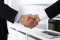 Businessman and woman shaking hands in office. Concept of handshake as success symbol in business Royalty Free Stock Photo