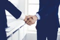 Businessman and woman shaking hands in office. Concept of handshake as success symbol in business Royalty Free Stock Photo