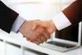 Businessman and woman shaking hands in sunny office, close-up. Concept of handshake as success symbol in business Royalty Free Stock Photo