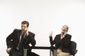 Businessman and woman sitting talking on cell phones.