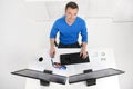 Businessman at work. Top View of young cheerful businessman sitting at his working place and smiling at camera