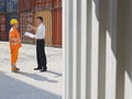 Businessman and worker with cargo containers