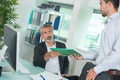 Businessman and worker discussing over documents in office Royalty Free Stock Photo