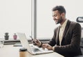 Businessman working on computer. Young smiling man using laptop in the office. Internet marketing, finance, business concept Royalty Free Stock Photo