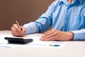 Businessman working on desk holding a pen in his hand using a calculator to calculate numbers. The concept of financial accounting Royalty Free Stock Photo