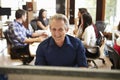 Businessman Working At Desk With Meeting In Background Royalty Free Stock Photo