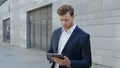 Businessman working on digital tablet in city. Manager browsing internet on pad Royalty Free Stock Photo