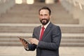 Businessman working on digital tablet in front staires to office building. Man holding digital tablet in hand Royalty Free Stock Photo