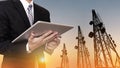 Businessman working on digital tablet, with satellite dish telecom network on telecommunication tower in sunset, telecommunication