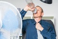 Businessman is working in a hot office and is drinking water Royalty Free Stock Photo