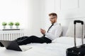 Businessman working from a hotel room with his mobile phone Royalty Free Stock Photo