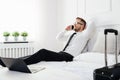 Businessman working from a hotel room with his mobile phone Royalty Free Stock Photo