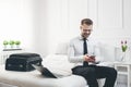 Businessman working from a hotel room with his mobile phone Royalty Free Stock Photo