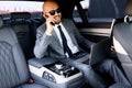 Businessman working on laptop in back seat of Executive car. Concept of business, success, traveling, luxury. Royalty Free Stock Photo