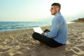 Happy businessman working with laptop on beach. Business trip Royalty Free Stock Photo