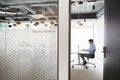 Businessman Working On Laptop At Boardroom Table Viewed Through Meeting Room Door Royalty Free Stock Photo