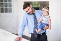 Businessman working on laptop while carrying daughter Royalty Free Stock Photo