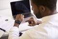 Businessman Working On Laptop At Desk In Modern Office Checking Data On Smart Watch