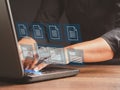 Businessman working at a laptop and digital documents with checkbox lists on virtual screen. Online documentation database and
