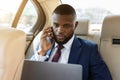 Businessman working on laptop, using smartphone while going to airport Royalty Free Stock Photo
