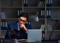 Businessman working late at night in office for overtime bonus Royalty Free Stock Photo