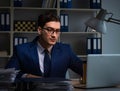 Businessman working late at night in office for overtime bonus Royalty Free Stock Photo