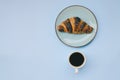 Businessman working morning with cups of hot black coffee and sweet croissant on blue background. Top view, copy space, mockup Royalty Free Stock Photo