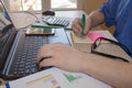 Man working on office desk with Calculator, a computer, a pen and document. Man counting money and making calculations Royalty Free Stock Photo