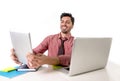 Businessman working at office desk using digital tablet pad smiling happy sitting in front of computer laptop looking satisfied Royalty Free Stock Photo