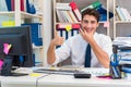 Businessman working in the office with piles of books and papers Royalty Free Stock Photo