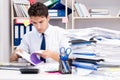 Businessman working in the office with piles of books and papers Royalty Free Stock Photo