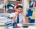 Businessman working in the office with piles of books and papers Royalty Free Stock Photo